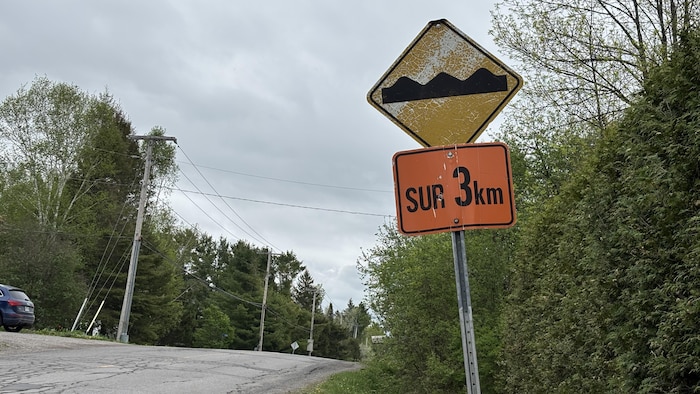 Un panneau de signalisation annonçant une zone de nids-de-poule.