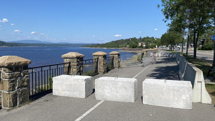 Des blocs de béton bloquent une piste cyclable.
