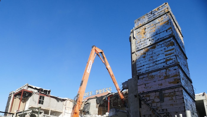 Excavatrice et bâtiments éventrés.