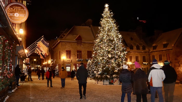 Un sapin géant au milieu d'une place en hiver.