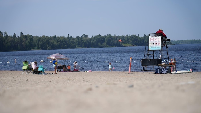 Un surveillant et des baigneurs sur une plage à Val-d'Or.