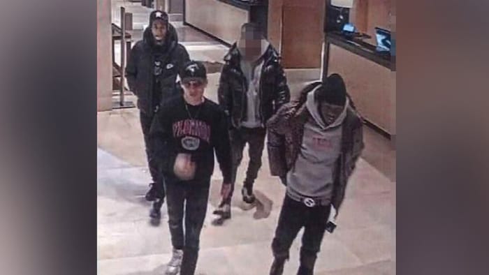 Une capture d’écran d’une caméra de surveillance qui montre quatre hommes dans le hall d’un hôtel.