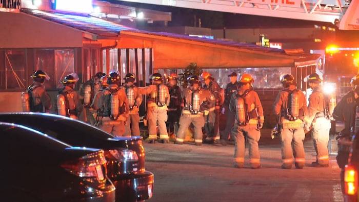 Une dizaine de pompiers devant un restaurant.