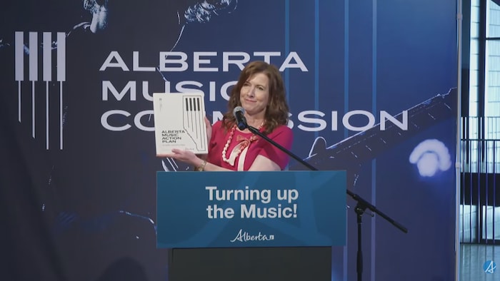 Tanya Fir montre le plan musique aux caméras lors de sa conférence de presse.