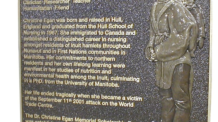 Une plaque avec une illustration qui représente Christine Egan qui porte un bébé inuit sur son dos, accompagné d'un texte qui commémore sa vie et ses réalisations.