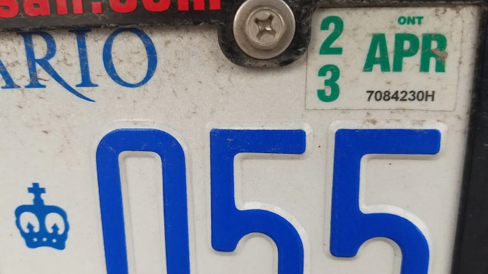 Une plaque d'immatriculation de voiture avec une vignette.