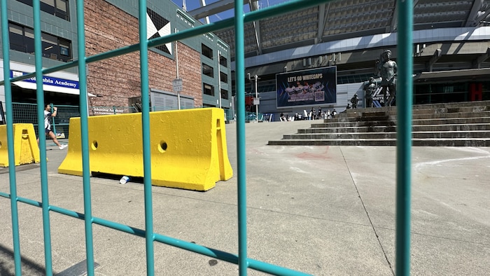 Des barrières en métal et en béton devant un stade 