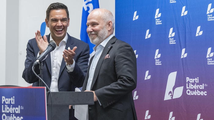 Deux hommes derrière un lutrin.