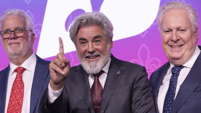 Le nouveau chef du Parti libéral du Québec, Pablo Rodriguez, est entouré des deux anciens premiers ministres Philippe Couillard (à gauche) et Jean Charest (à droite). 