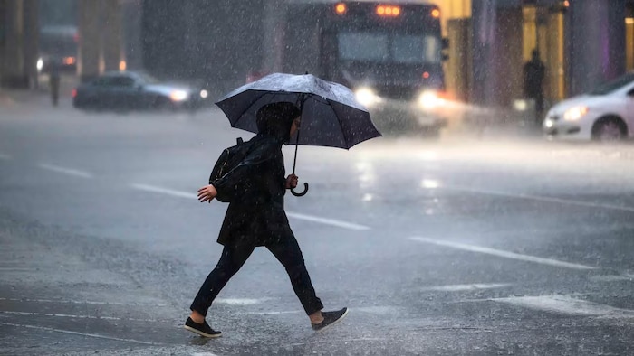 Une personne sous une forte pluie.