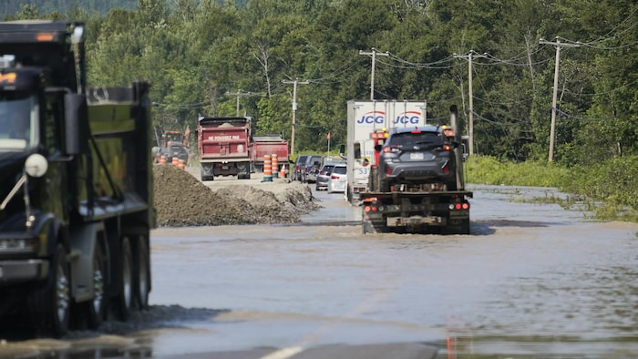Une butte de sable retient l'eau de la rivière qui déborde.