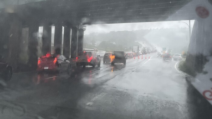 Rain falls on the cars on the highway.