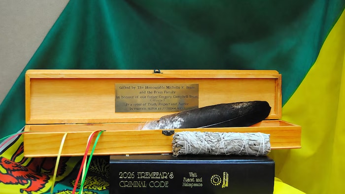 Une plume d'aigle déposée dans un étui en bois.
