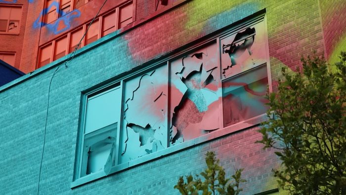 Les fenêtres brisées de l'édifice sont aussi recouvertes de peinture. 