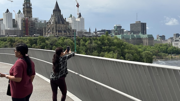Une personne prend des photos sur la pointe Kìwekì à Ottawa.