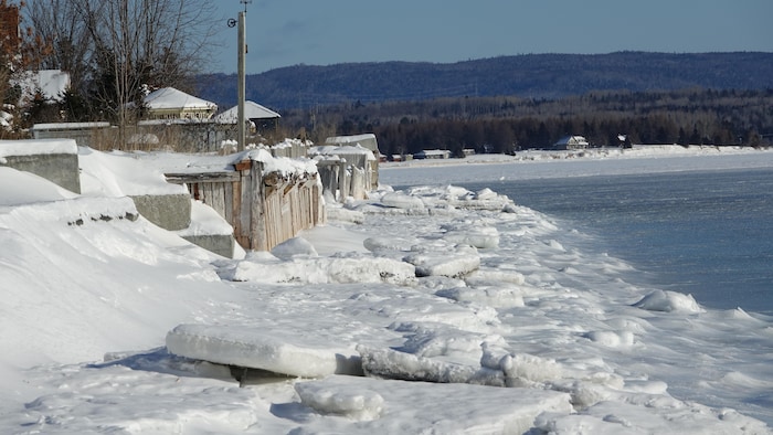 Des blocs de glace sont en bas d'un mer de protection abîmé, le long du terrain de plusieurs résidences de la pointe Verte, à Maria.