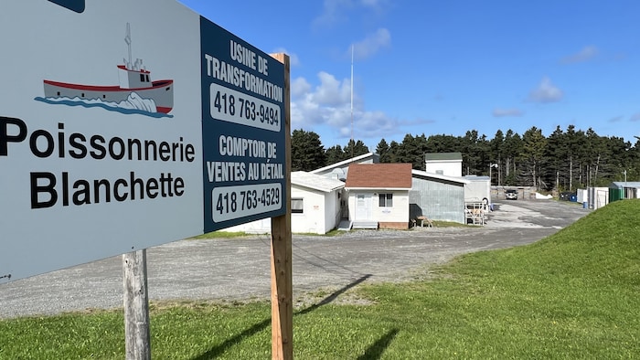Enseigne de l'usine de transformation Poissonnerie Blanchette avec installations en arrière-plan. 