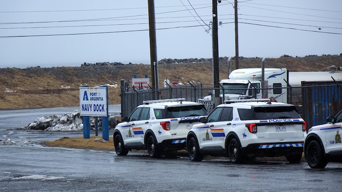 Des voitures de police stationnées devant l'entrée du port d'Argentia.