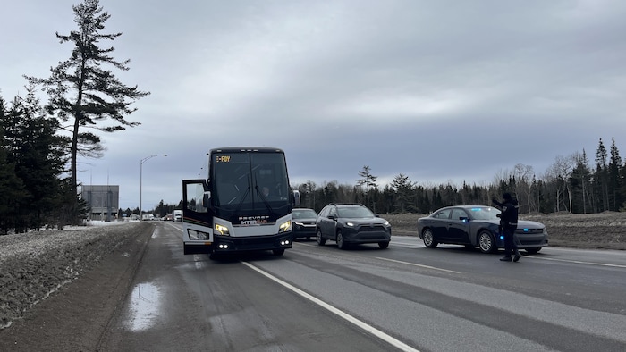 Un autobus et des policiers sur une route.