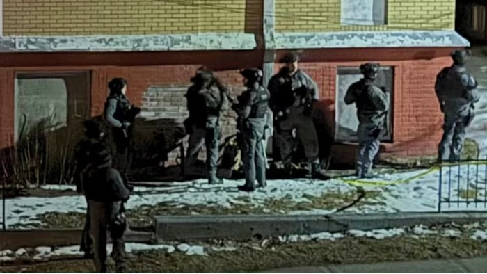 Huit policiers postés près d’une maison de la rue Lansdowne à Sudbury, où un homme a été retrouvé mort dans une camionnette.