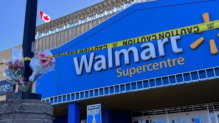 Des fleurs et un ruban jaune devant un magasin Walmart.
