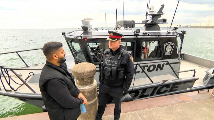Reetinder Sandhu et Jeff Hill discutent devant le bateau de la police régionale de Halton le 7 mai 2026.