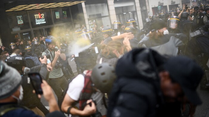 Des manifestants tentent d'éviter des tirs de gaz lacrymogènes.