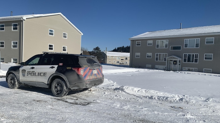 Une autopatrouille de la police de Saint-Jean devant deux immeubles..