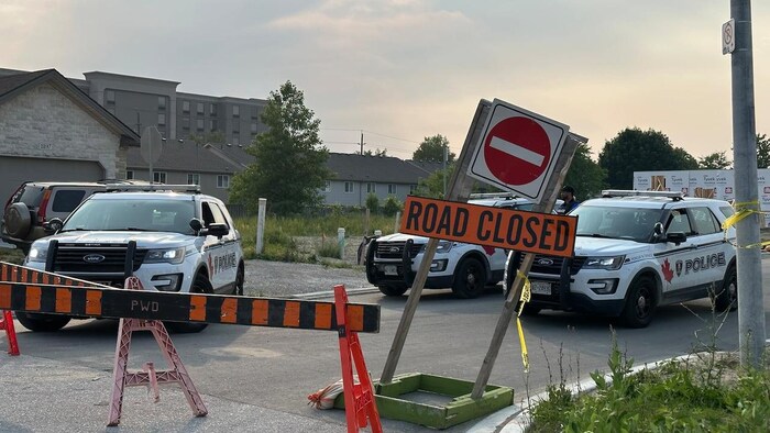 Des voitures de police derrière des barrières.
