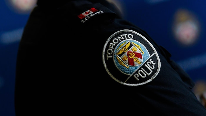 Le logo du Service de police de Toronto sur l’uniforme d’un policier.