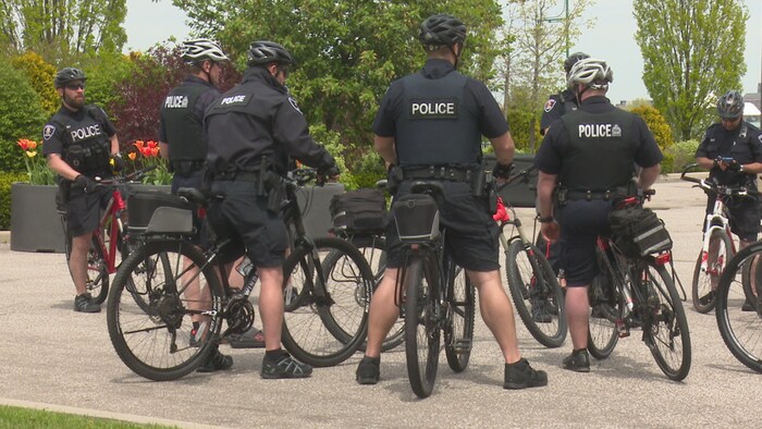 Des policiers de dos sur leur vélos.