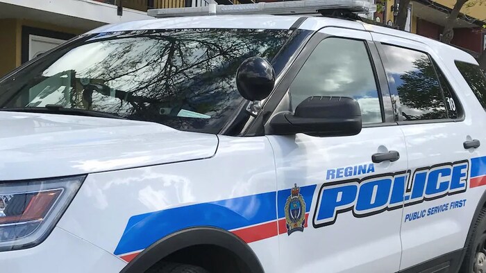 Un véhicule de la police de Regina est garé devant un immeuble.