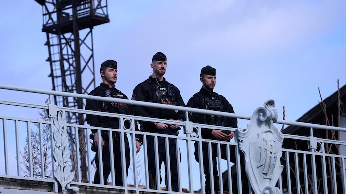 Des policiers français montent la garde sur une passerelle.