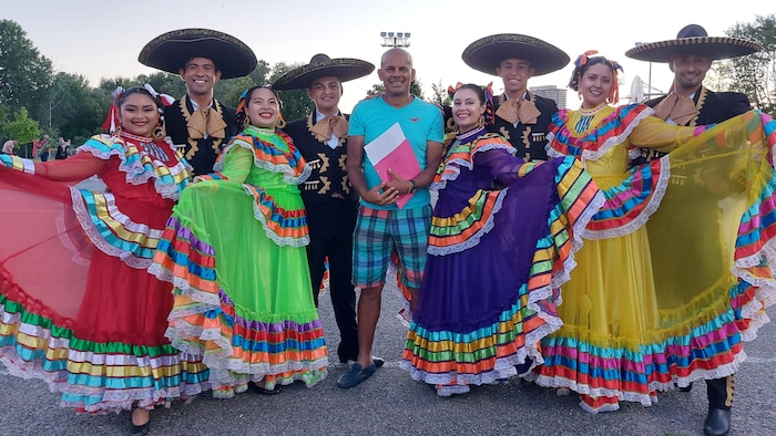 Un homme pose avec des danseurs en costumes traditionnels mexicains.