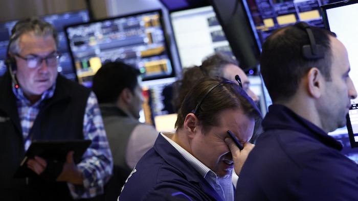 Des agents travaillent sur le parquet de la Bourse de New York lors de l'ouverture des marchés.