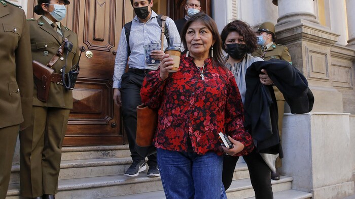 Une femme, un café à la main, quitte le Palace Peireira au Chili.