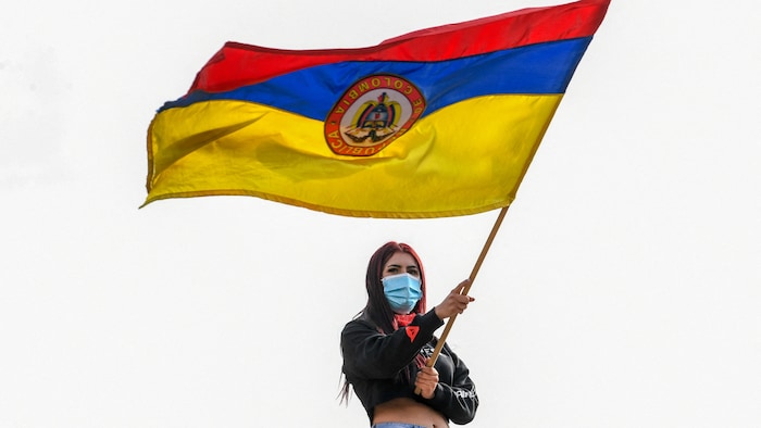 Une femme portant un masque sanitaire agite un drapeau de la Colombie lors d'une manifestation à Bogota, le 6 mai 2021.