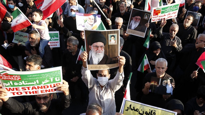 Des manifestants brandissent des affiches en soutien au guide suprême iranien, l'Ayatollah Ali Khamenei.