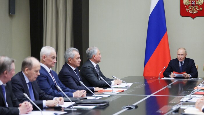 Vladimir Poutine, au bout de la table, s'adresse à ses conseillers.
