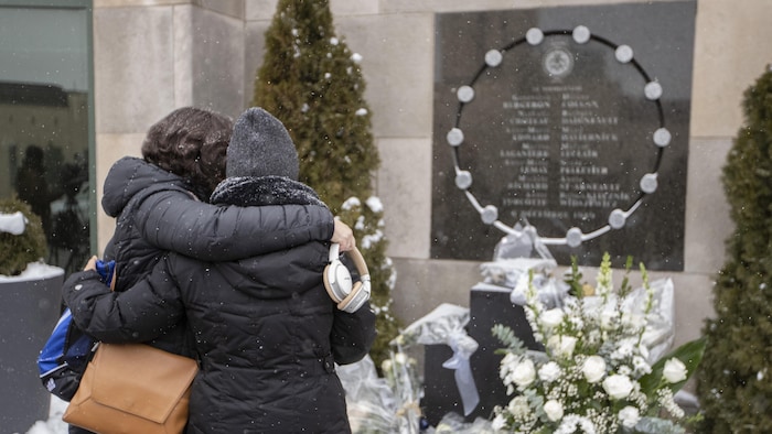 Des femmes se réconfortent devant le monument commémoratif du 6 décembre 1989.