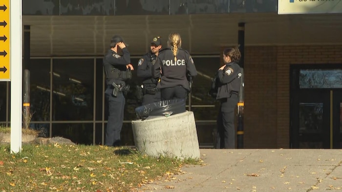 Quatre policiers devant une école.