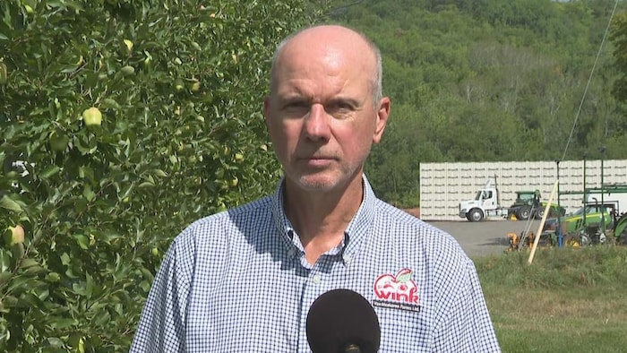 Stephen Van Meekeren devant des pommiers.