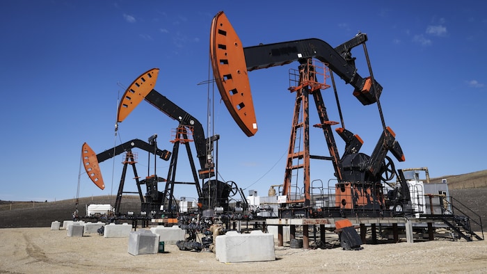 Trois pompes extraient le pétrole et le gaz du sol.