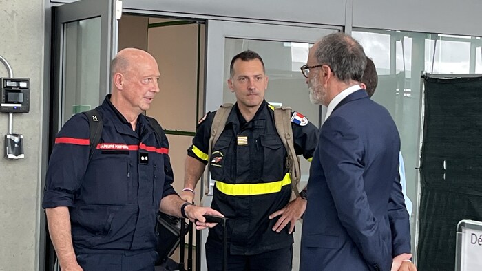 Des pompiers parlent avec le consul de France.
