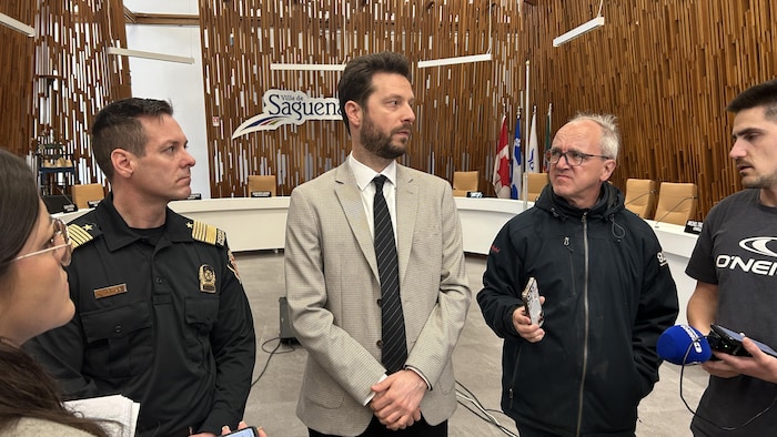 Deux personnes répondent à des questions des journalistes.