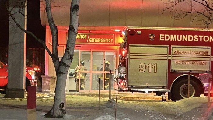 Deux pompiers entrent dans le bâtiment via l'entrée de l'urgence de l'hôpital régionale d'Edmundston. 