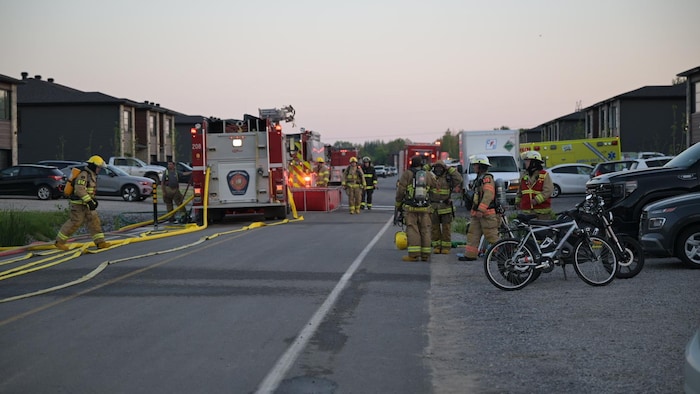Firefighters and trucks in a residential street. fire devastation houses row saint-maurice fire devastation houses row saint-maurice new