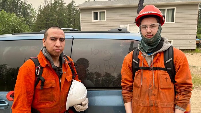 Deux pompiers posent pour une photo.