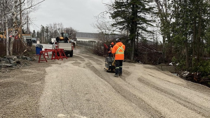 Un chemin en gravier termine d'être damné par un travailleur de la Ville de Chandler.