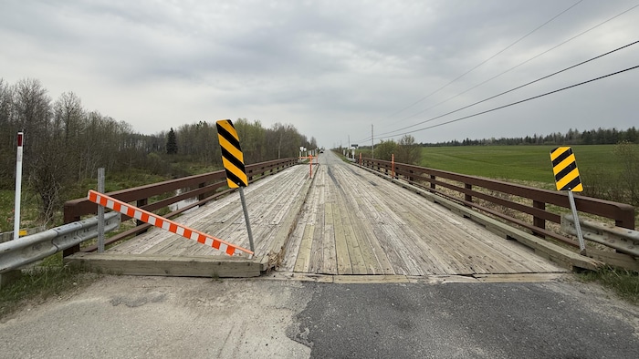 Un pont de bois dont une section est bloquée à la circulation.